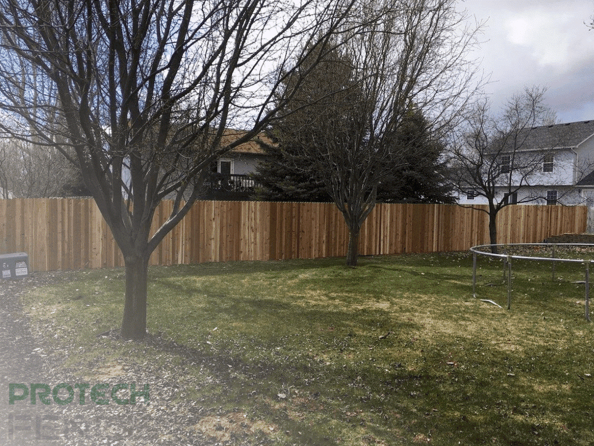 Custom-crafted wood fence installation done by Protech, showcasing timeless elegance, charming appeal, and rustic beauty. Tailored to reflect personal style and complement home architecture.