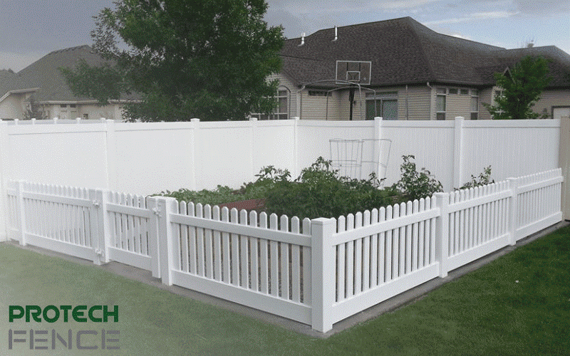 A captivating scene of a sturdy, white picket vinyl fence installation gracefully enclosing a small garden in a backyard, showcasing the meticulous vinyl fence installation of Protech Fence Company, Idaho's Best Fence and Deck Company. 