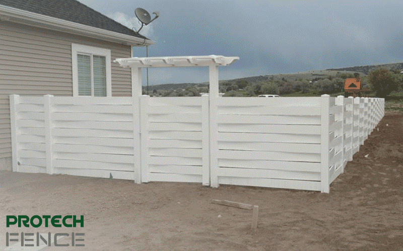 A view of a white, framed gate and vinyl fence installation done by Protech Fence Company, showcasing our industry leadership and commitment to personalized, high-quality fencing solutions in Idaho Falls. 