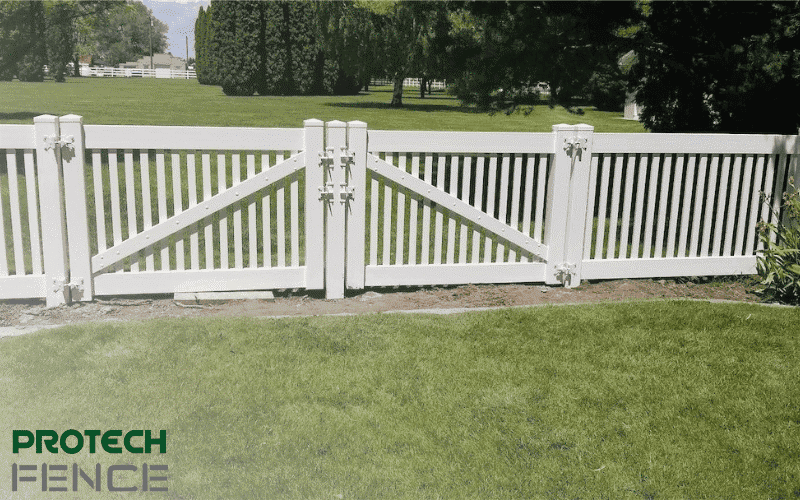 A picturesque view of a vinyl fence installation by Protech Fence Company featuring a framed courtyard with a cap fence and gate. 